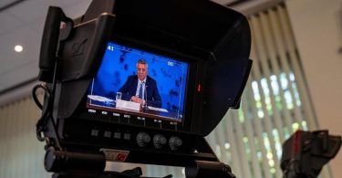 Auf einem Videomonitor ist Lothar H. Wieler, Präsident des Robert Koch-Instituts (RKI), zu sehen. Foto: John Macdougall/AFP-Pool/dpa
