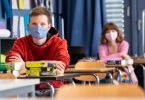 Schüler und Schülerinnen eines Gymnasiums tragen Mundschutze. Foto: Sven Hoppe/dpa