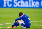 Schalkes Benito Raman sitzt nach dem Abpfiff auf dem Rasen. Foto: Guido Kirchner/dpa