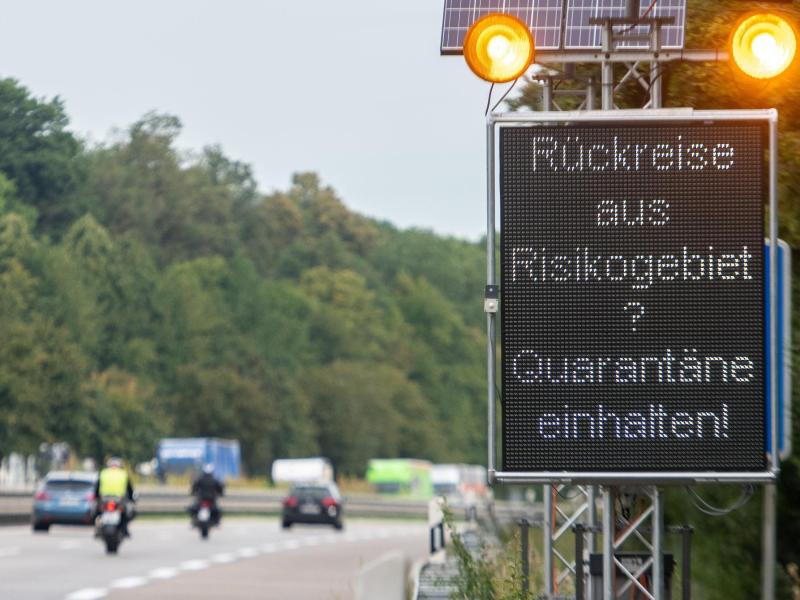 Auf der Autobahn A7 werden Reisende aus Risikogebieten mit einer Leuchttafel "Rückreise aus Risikogebiet? Quarantäne einhalten!" auf die notwendigen Quarantänemaßnahmen hingewiesen. Foto: Stefan Puchner/dpa