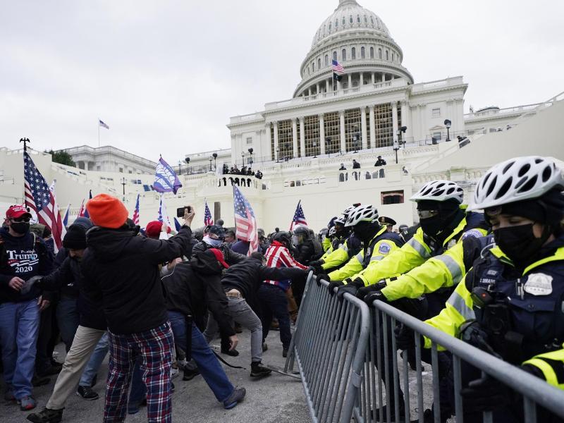 Trump-Unterstützer versuchen eine Absperrung vor dem Kapitol zu durchbrechen. Die Kongresssitzungen wurden daraufhin unterbrochen. Foto: John Minchillo/AP/dpa