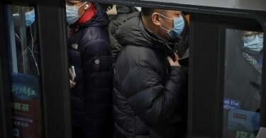 Pendler in Peking drängen sich während der Hauptverkehrszeit in eine U-Bahn. Foto: Andy Wong/AP/dpa