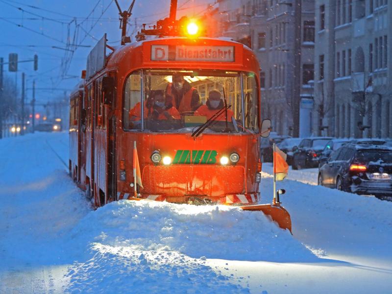 Eine Straßenbahn mit Schneepflug der Magdeburger Verkehrsbetriebe befreit die Gleise von Schnee und Eis. Foto: Peter Gercke/dpa-Zentralbild/dpa