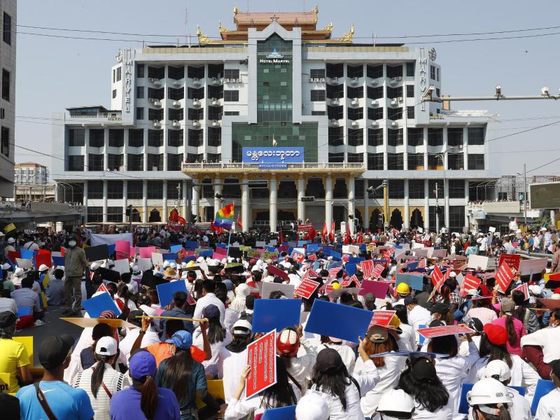 Teilnehmer eines Protestmarschs gegen den Militärputsch versammeln sich mit Plakaten vor dem Bahnhofsgebäude in Mandalay. Foto: Uncredited/AP/dpa