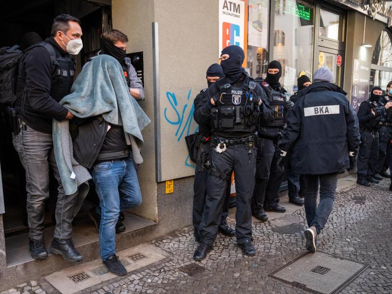 Ein Mann wird bei einer Razzia, mit einer Decke über dem Kopf, von der Polizei abgeführt. Mit einer Großrazzia ist die Polizei am Donnerstag gegen Clankriminalität in Berlin und Umgebung vorgegangen. Foto: Christophe Gateau/dpa