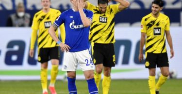 Schalkes Bastian Oczipka (vorne) steht enttäuscht im Vordergrund - im Hintergrund feiern die Dortmunder das zweite Tor ihrer Mannschaft. Foto: Martin Meissner/Pool AP/dpa