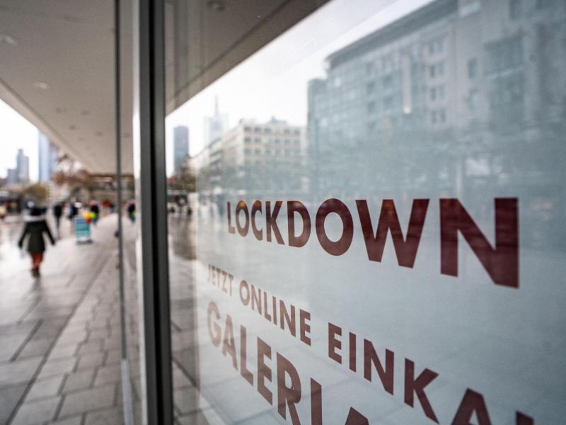 «Lockdown» steht im Schaufenster eines geschlossenen Kaufhauses, das darunter zum Online-Einkauf rät. Foto: Frank Rumpenhorst/dpa