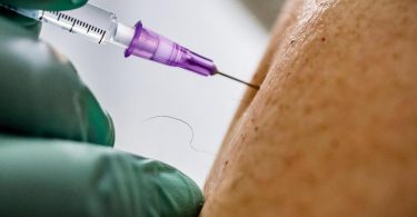 Ein Arzt verimpft eine Dosis des Biontech/Pfizer-Impfstoffs. Foto: Michael Kappeler/dpa