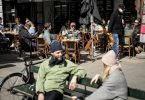 Menschen sitzen im belebten Außenbereich eines Cafés in der dänischen Haupstadt Kopenhagen. Foto: Mads Claus Rasmussen/Ritzau Scanpix/dpa