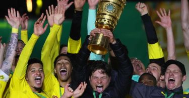 BVB-Coach Edin Terzic streckt den DFB-Pokal in den Berliner Nachthimmel. Foto: Martin Rose/Getty-Pool/dpa