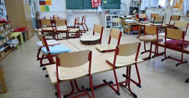 Stühle sind in einem leeren Klassenzimmer in einer Schule in Frankfrut auf den Tischen abgestellt. Foto: Arne Dedert/dpa