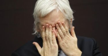 WikiLeaks-Gründer Julian Assange hält die hände vor das Gesicht während einer Pressekonferenz. Foto: Lefteris Pitarakis/AP/dpa