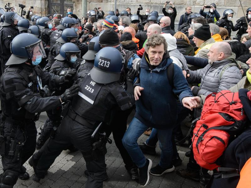 Einsatzkräfte der Polizei halten bei einer Kundgebung Teilnehmer zurück. Foto: Swen Pförtner/dpa