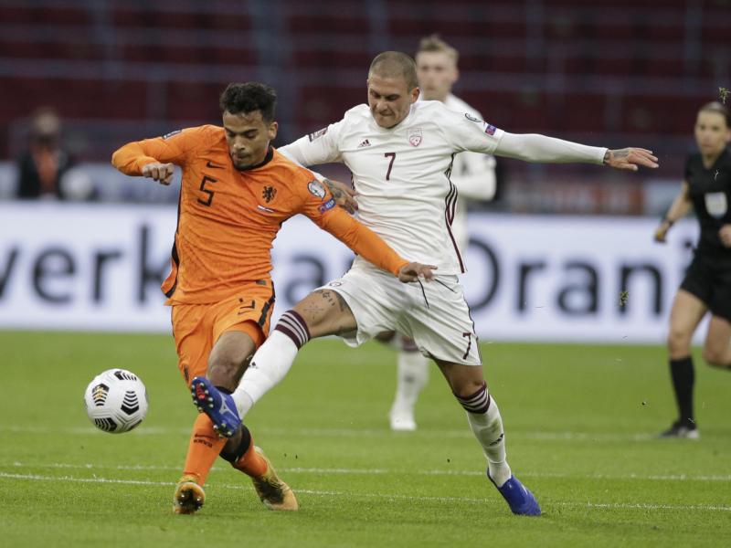 Der Lette Antonijs Cernomiordijs (r) und der Niederländer Owen Wijndal kämpfen um den Ball. Foto: Peter Dejong/AP/dpa