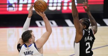 Luka Doncic (l) von den Dallas Mavericks wirft über Clippers-Starspieler Kawhi Leonard. Foto: Mark J. Terrill/AP/dpa