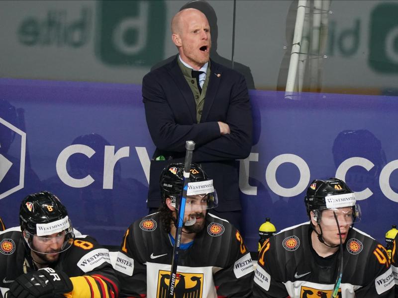 Bundestrainer Toni Söderholm (hinten) ruft Anweisungen an seine Spieler auf dem Eis. Foto: Roman Koksarov/dpa