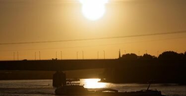 Über dem Rhein bei Köln geht die Sonne auf. Foto: Henning Kaiser/dpa