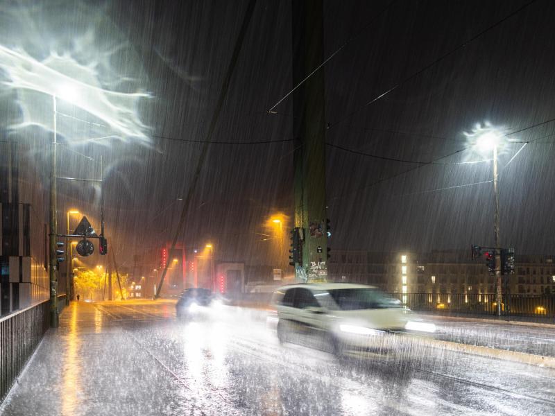 Autos fahren bei Starkregen und Gewitter durch Düsseldorf. Foto: Marcel Kusch/dpa