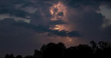Über Berlin blitzt es hinter dunklen Wolken. Foto: Fabian Sommer/dpa