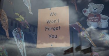 «Wir werden Euch nicht vergessen» steht auf einem Plakat im Fenster einer Schule in British Columbia, nachdem dort die Überreste von 215 Kindern gefunden worden waren. Nun sind in Zentralkanada 751 unmarkierte Gräber entdeckt worden. Foto: Darryl Dyck/The Canadian Press/dpa