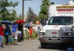 Ein Rettungswagen der Heilsarmee dient als Kühlstation, während die Menschen Schlange stehen, um in einen Wasserpark zu gelangen. Foto: Jeff Mcintosh/The Canadian Press via ZUMA/dpa