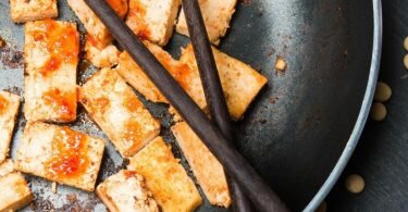 In Sojasauce marinierter und gebratener Tofu wird noch knuspriger, wenn man zuvor Flüssigkeit herauspresst. Foto: Franziska Gabbert/dpa-tmn