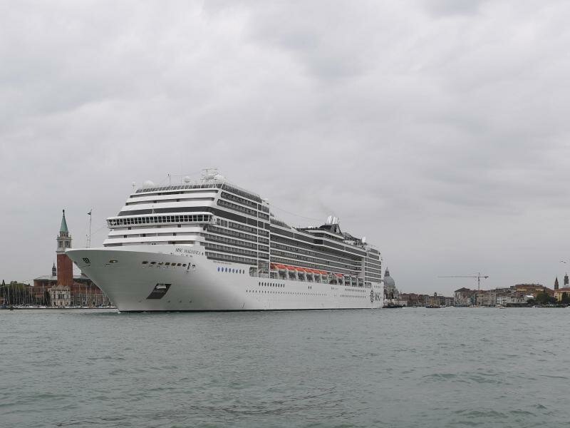 Ein Kreuzfahrtschiff fährt an der Lagunenstadt Venedig von einem Schlepper gezogen vorbei. Foto: Felix Hörhager/dpa