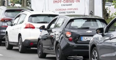 Eine lange Schlange bildet sich vor der Einfahrt zur Impfung an der Ikea-Filiale Lichtenberg vor dem Schild mit der Aufschrift "Impf-Drive-In Einfahrt Corona-Impfung Ohne Termin". Foto: Fabian Sommer/dpa