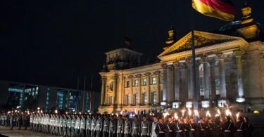 Zahlreiche Soldaten stehen bei einem Großen Zapfenstreich vor dem Reichstagsgebäude in Berlin. Foto: picture alliance / dpa