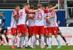Die Mannschaft von Regensburg feiert den Führungstreffer gegen Sandhausen. Foto: Armin Weigel/dpa