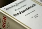 ILLUSTRATION - Das Strafgesetzbuch liegt in einem Gerichtssaal. Foto: Oliver Berg/dpa