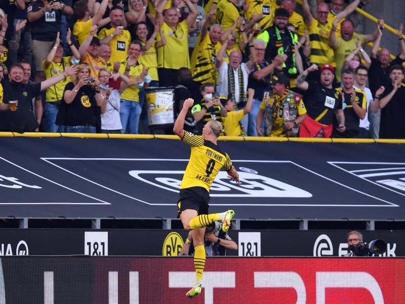 Dortmunds Erling Haaland springt jubelnd in Richtung Fans. Foto: Marius Becker/dpa