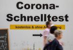 Ein Schild weist am Münchner Rathaus den Weg zu kostenlosen Corona-Schnelltest ohne Anmeldung. Foto: Peter Kneffel/dpa