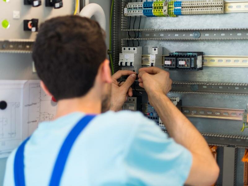 Ein Azubi aus Afghanistan arbeitet an einem Schaltschrank. Foto: Monika Skolimowska/dpa-Zentralbild/dpa