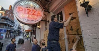 Die Scheiben eines Restaurants in New Orleans werden mit Holzpanelen vor der Ankunft des Hurrikans «Ida» geschützt. Foto: Matthew Hinton/AP/dpa