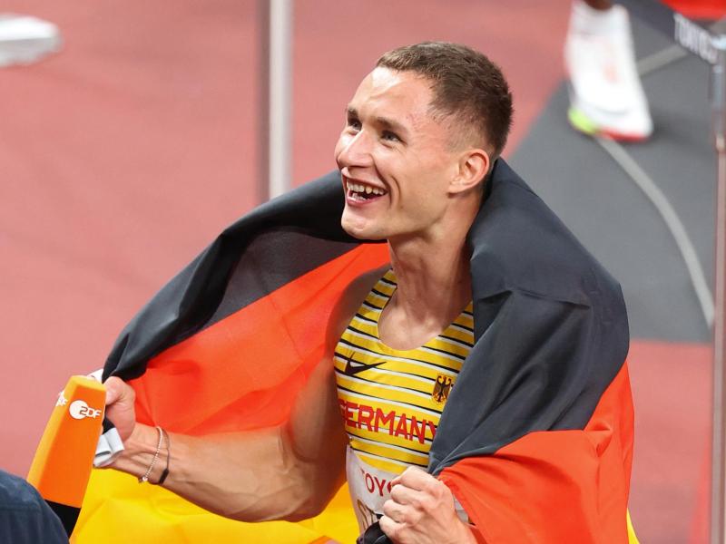 Goldmedaillengewinner Felix Streng jubelt nach dem Rennen mit der deutschen Fahne. Foto: Karl-Josef Hildenbrand/dpa