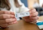Gesund: Ein Schülerin zeigt in einer Klasse ihren negativen Corona-Schnelltest. Foto: Sebastian Gollnow/dpa