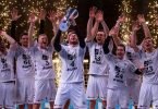 Die Kieler Spieler jubeln mit dem Pokal. Foto: Marius Becker/dpa