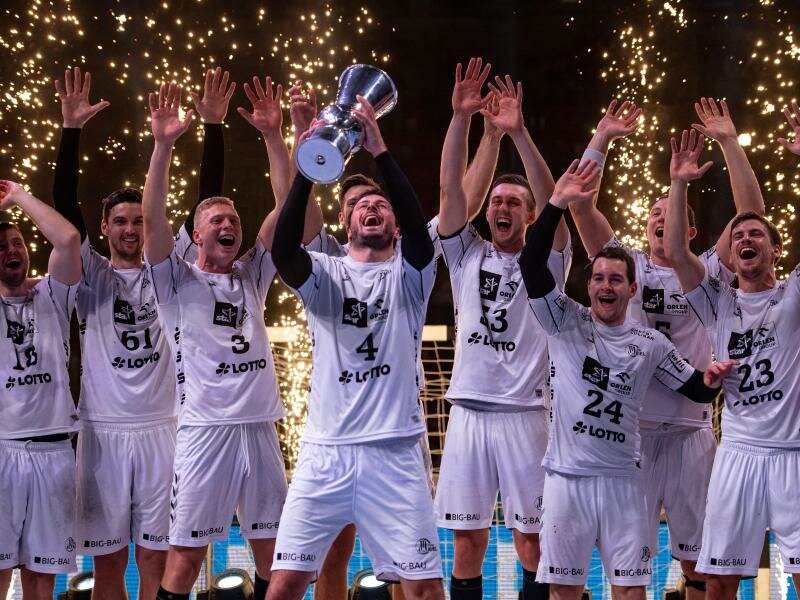 Die Kieler Spieler jubeln mit dem Pokal. Foto: Marius Becker/dpa