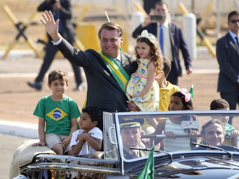 Jair Bolsonaro (M) kommt zu einer Flaggenhissungszeremonie in der Präsidentenresidenz. Foto: Eraldo Peres/AP/dpa