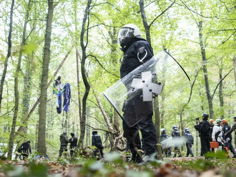 Polizisten stehen im September 2018 vor einer Barrikade im Hambacher Forst, in der sich eine Aktivistin festgebunden hat. Foto: Marcel Kusch/dpa