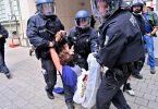 Eine Protestteilnehmerin wird von Polizisten weggetragen. Foto: Peter Kneffel/dpa
