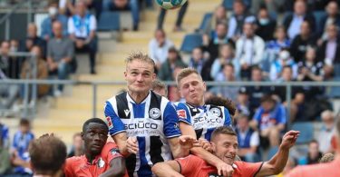 Bielefelds Amos Pieper (oben, l) setzt sich im Kopfballduell gegen Hoffenheims Diadie Samassekou (unten, l-r) und Pavel Kaderabek durch. Foto: Friso Gentsch/dpa