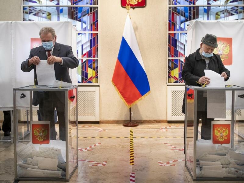 Russische Bürger geben ihre Stimmzettel ab. Foto: Mindaugas Kulbis/AP/dpa
