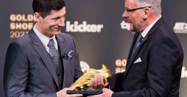 Jörg Jakob (r), Kicker-Chefredakteur, übergibt den Goldenen Schuh 2021 an Fußballprofi Robert Lewandowski. Foto: Michael Gottschalk/Kicker via picture alliance/dpa