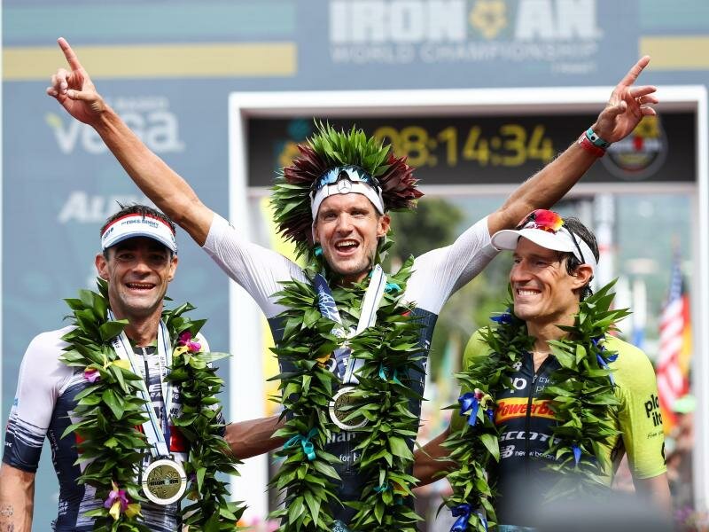 Jan Frodeno (M) feiert auf Hawaii beim letzten Ironman 2019 seinen Sieg. Foto: David Pintens/BELGA/dpa