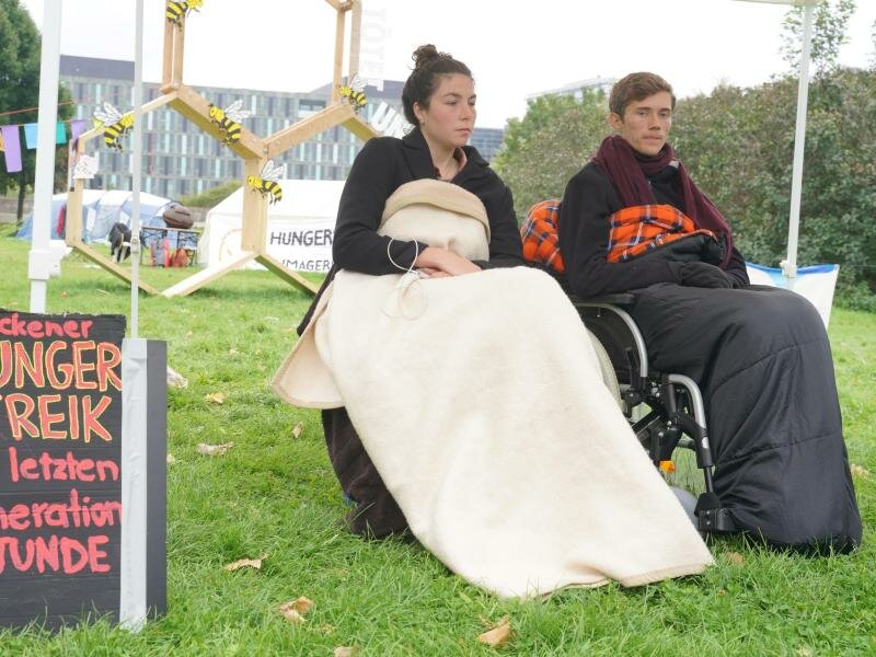 Lea und Henning, die beiden verbliebenen Teilnehmer des «Hungerstreiks der letzten Generation», verschärften ihre Aktion, bevor sie sie schließlich beendeten. Foto: Jörg Carstensen/dpa