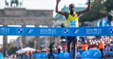 Guye Adola aus Äthiopien läuft beim Berlin Marathon nach 2:05:45 Stunden als Erster durchs Ziel. Foto: Andreas Gora/dpa