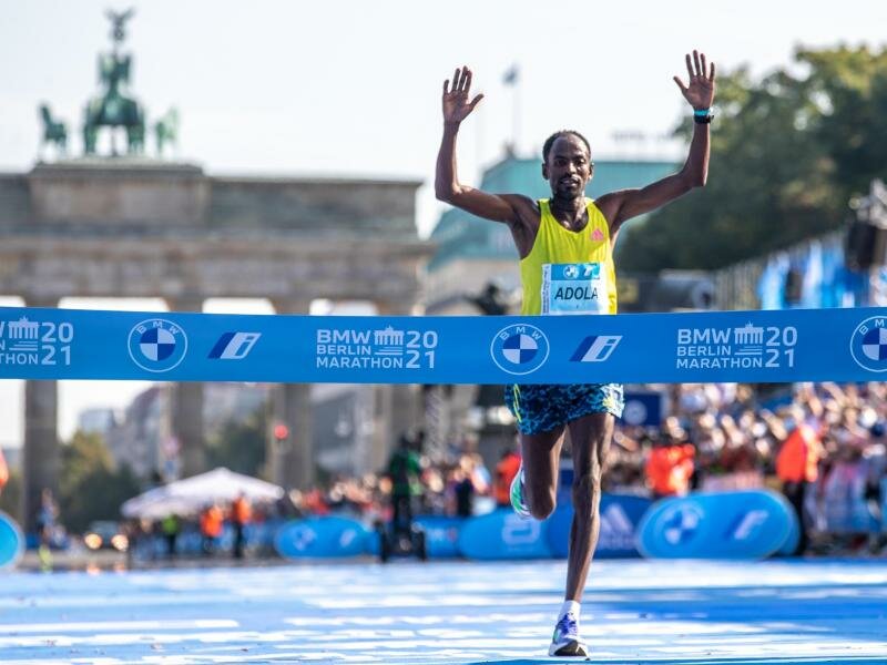 Guye Adola aus Äthiopien läuft beim Berlin Marathon nach 2:05:45 Stunden als Erster durchs Ziel. Foto: Andreas Gora/dpa