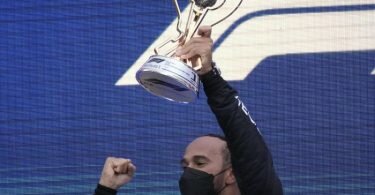 Weltmeister Lewis Hamilton mit der Siegertrophäe. Foto: Sergei Grits/AP/dpa